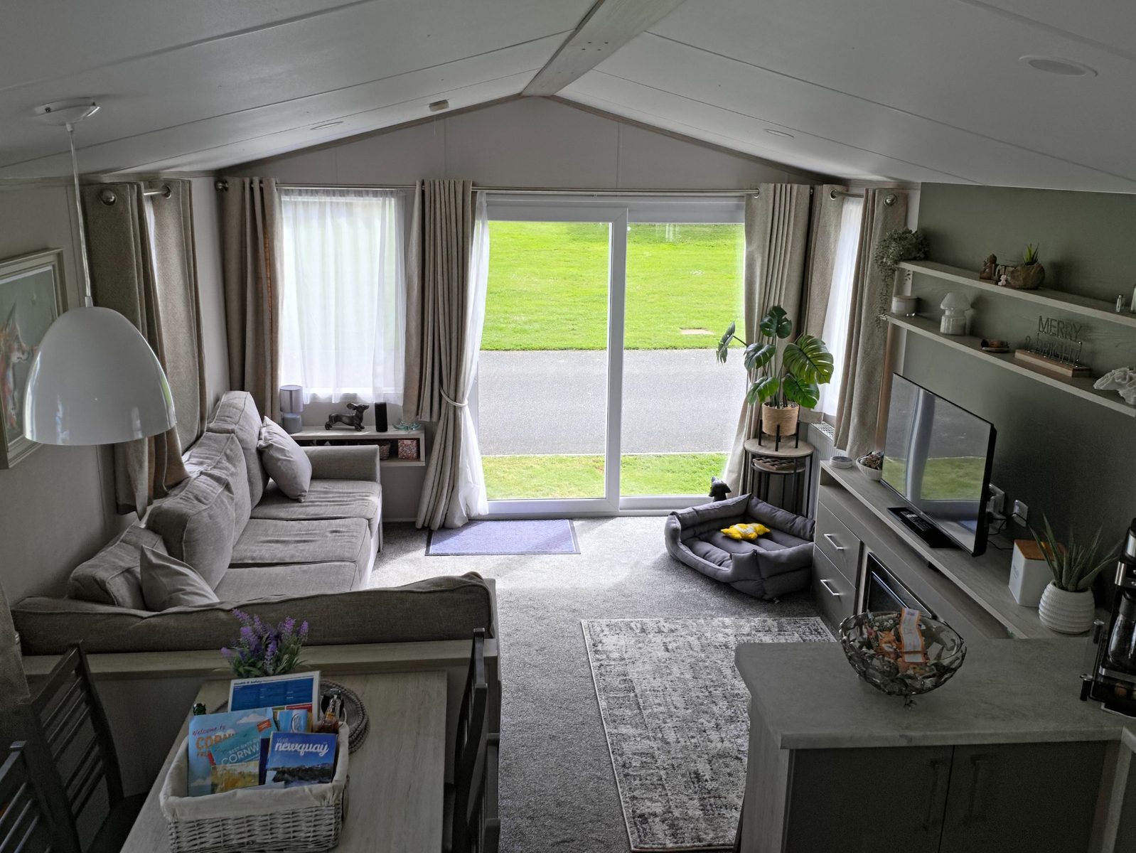 Open-plan living room with sofa seating, sliding doors and bright natural light.