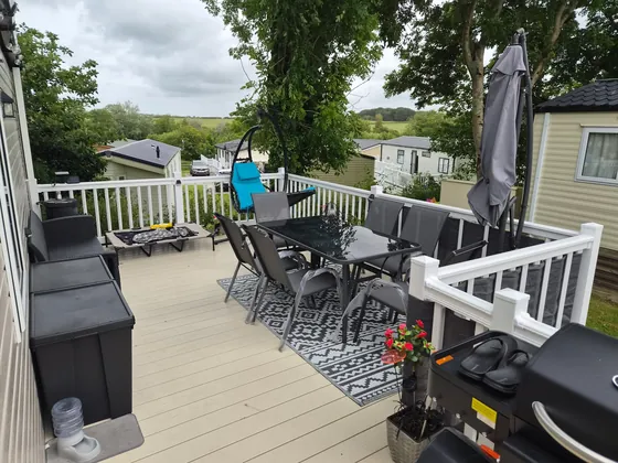 Spacious private decking with outdoor dining, seating and parasol.