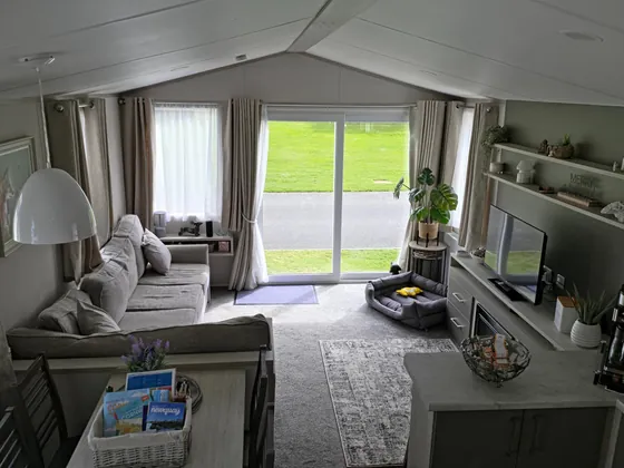 Open-plan living room with sofa seating, sliding doors and bright natural light.