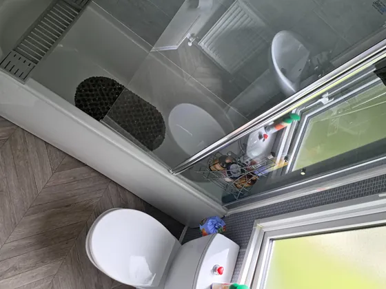 Shower over bath with glass screen.