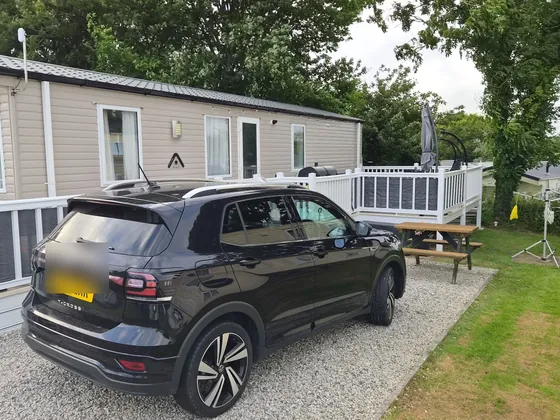 Side view of the caravan, decking and outdoor seating area.