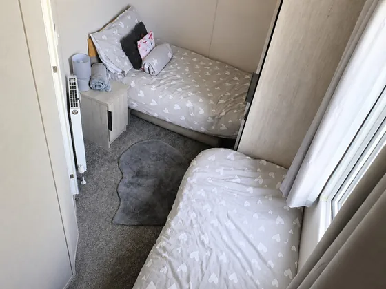 Twin bedroom with two single beds, fresh bedding and neutral decor.